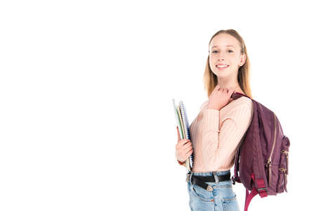 Smiling teenager with notebooks and backpack isolated on whiteの写真素材