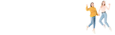 Horizontal image of cheerful teenagers jumping and waving hands isolated on whiteの写真素材