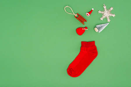 top view of red christmas stocking near festive baubles on green background with copy spaceの写真素材