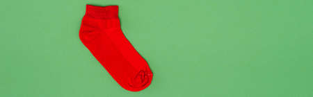 website header of red christmas stocking on green background with copy spaceの写真素材