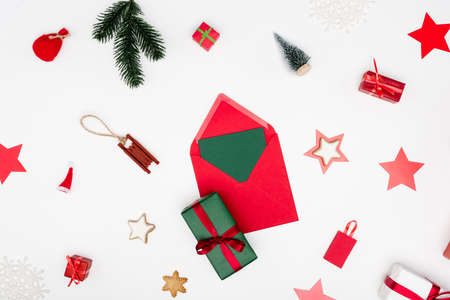 top view of red envelope with card near christmas baubles on white background