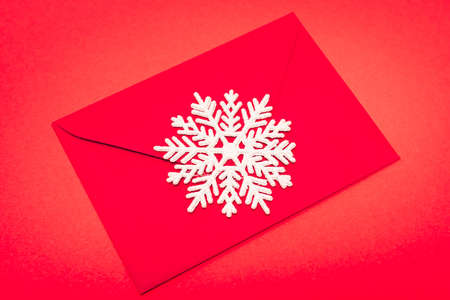 top view of snowflake and envelope on red backgroundの写真素材