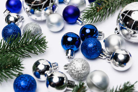blue, silver Christmas decoration and fir branches on white backgroundの写真素材