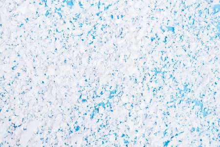 Top view of artificial snow on blue background, new year concept
