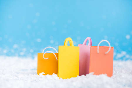 Surface level of tiny paper bags with artificial snow on blurred background, new year conceptの写真素材