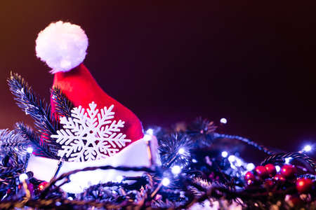 Surface level of santa hat with decorative snowflakes, pine branches and christmas lights, new year conceptの写真素材