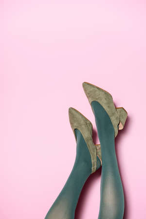 cropped view of female legs in green tights and retro shoes on lilac backgroundの写真素材