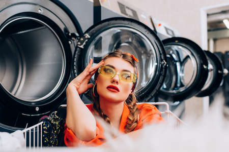 pensive woman near washing machines with blurred foregroundの写真素材