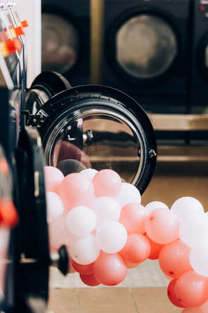 balloons near modern washing machines in laundromat with blurred foreground