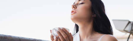 beautiful brunette woman enjoying drinking coffee with closed eyes, horizontal banner