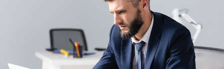 Businessman in formal wear looking away in office, bannerの写真素材