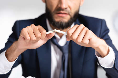 broken pencil in hands of stressed businessman on blurred backgroundの写真素材