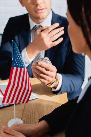 partial view of journalist with dictaphone and pen interviewing politician during press conference,...