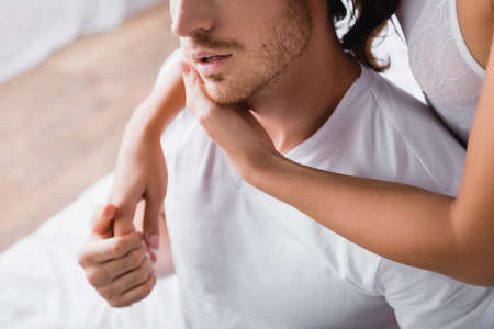 cropped view of woman hugging boyfriend in bedroom