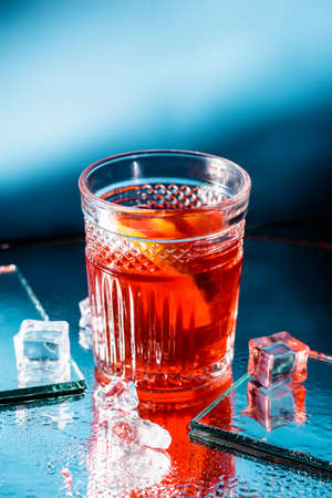 mixed alcohol cocktail with whiskey near ice cubes on blueの写真素材