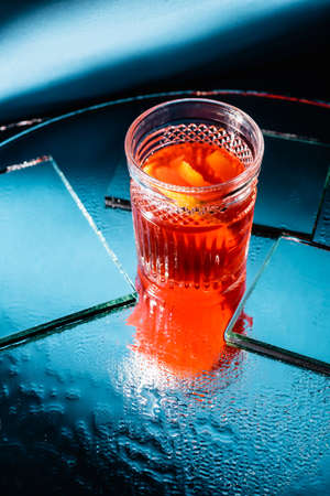 mixed alcohol cocktail with whiskey near mirrors on surface and blue backgroundの写真素材