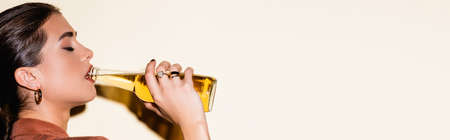 side view of brunette woman drinking beer on white, banner