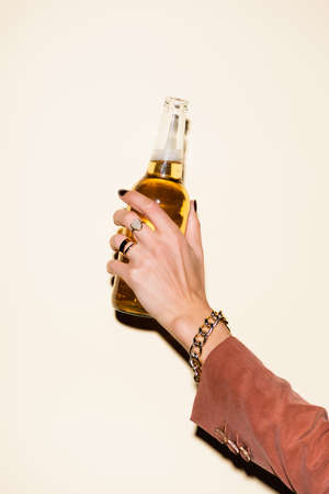 cropped view of woman holding bottle with beer on whiteの写真素材