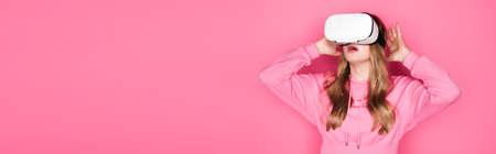 shocked beautiful woman in vr headset on pink background, banner