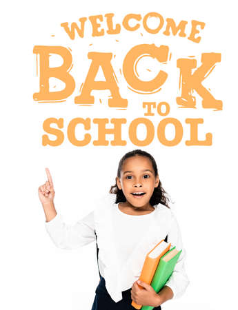 african american schoolgirl pointing with finger at welcome back to school illustration while...