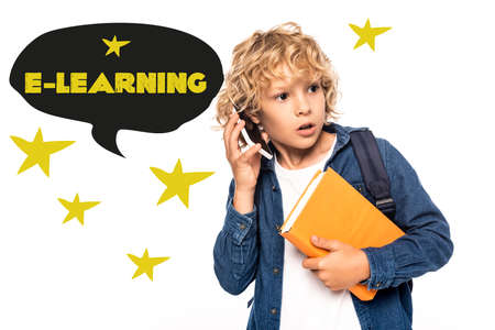 curious schoolboy holding book and talking on smartphone near e-learning lettering in speech bubble...