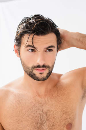 Shirtless man with wet hair looking away on gray backgroundの写真素材