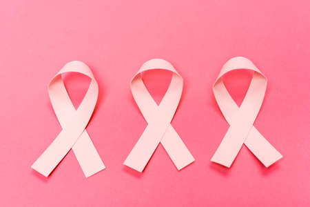 Top view of ribbons of breast cancer awareness on pink backgroundの写真素材