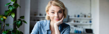 young blonde woman leaning chin on hand, horizontal banner