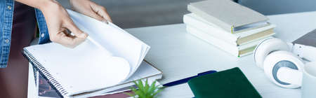 cropped view of woman turning pages of notebook, horizontal banner