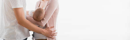 cropped view of caring woman holding in arms infant boy near husband, bannerの写真素材