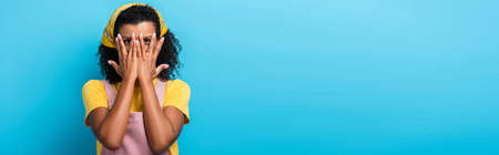 African american woman covering face with hands on blue, banner