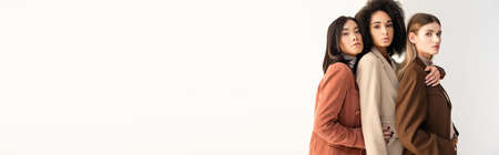 young interracial women in pastel formal wear posing on white, bannerの写真素材