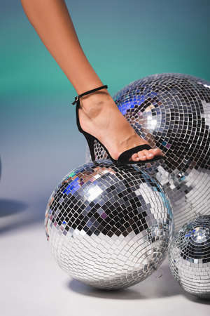 female leg in black shoe on disco ballの写真素材