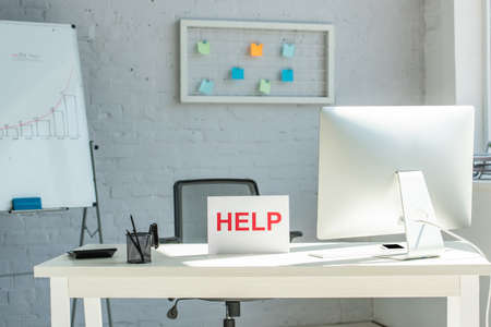 Interior of modern workplace and sign with help letteringの写真素材