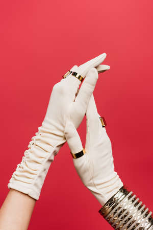 cropped view of woman in gloves with rings and bracelet isolated on redの写真素材