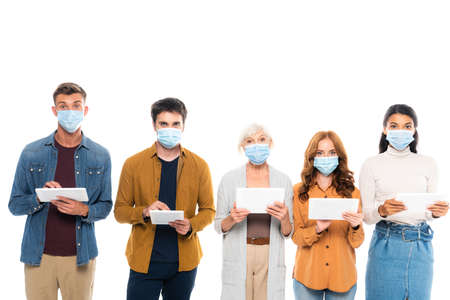 Multicultural people wearing medical masks and using digital tablets isolated on whiteの写真素材