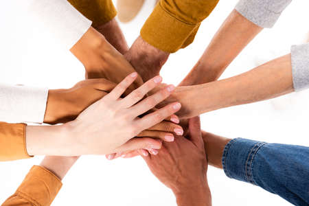 Top view of multiethnic people holding hands isolated on white