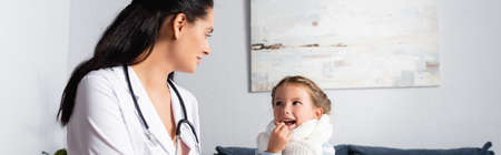 pediatrician doctor looking at ill girl taking pill, bannerの写真素材
