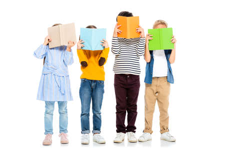 Kids holding colorful books near faces on white backgroundの写真素材
