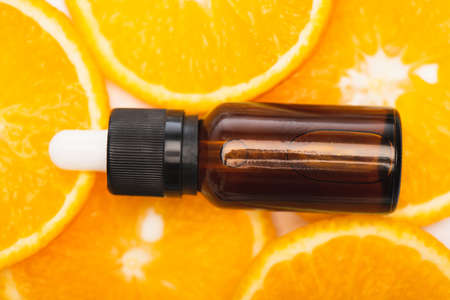 close up view of bottle with citrus essential oil on juicy, fresh orange slices, top viewの写真素材