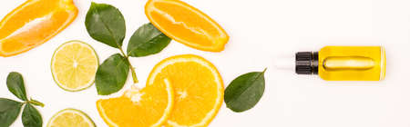 top view of orange slices and rose leaves near bottle with citrus essence on white, banner