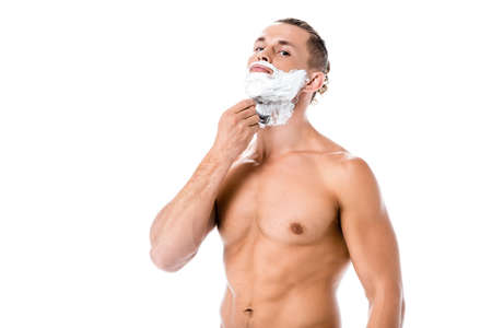 sexy shirtless man with foam on face shaving isolated on whiteの写真素材