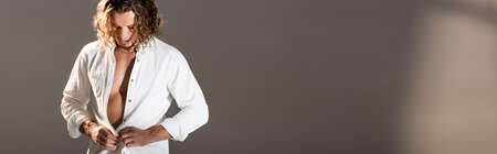 sexy man with unbuttoned shirt posing on dark background, bannerの写真素材