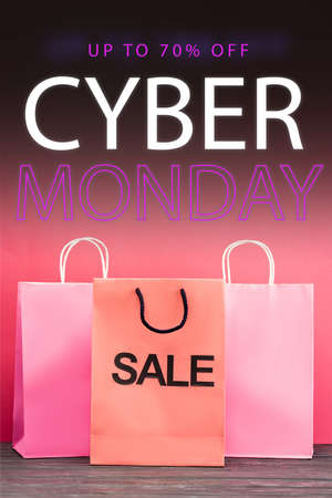 shopping bag with sale near paper bags near up to 70 percent off, cyber monday lettering on pink,...