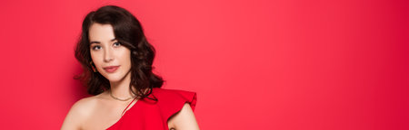 Brunette woman in red dress looking at camera on red background, bannerの写真素材