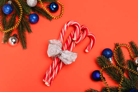 top view of decorated Christmas tree and candy canes on red backgroundの写真素材
