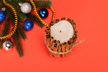 top view of decorated Christmas tree and candle on red backgroundの写真素材