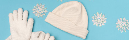 top view of winter white knitwear and snowflakes on blue background, bannerの写真素材