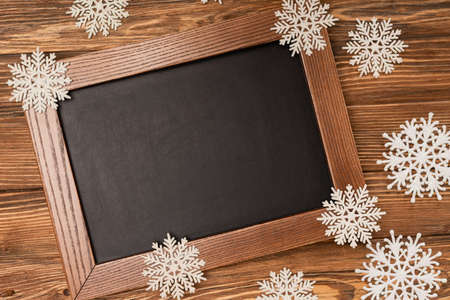 top view of winter snowflakes on chalkboard on wooden backgroundの写真素材