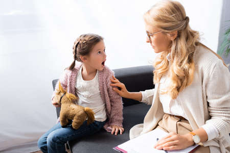 little girl with toy screaming while visiting psychologistの写真素材